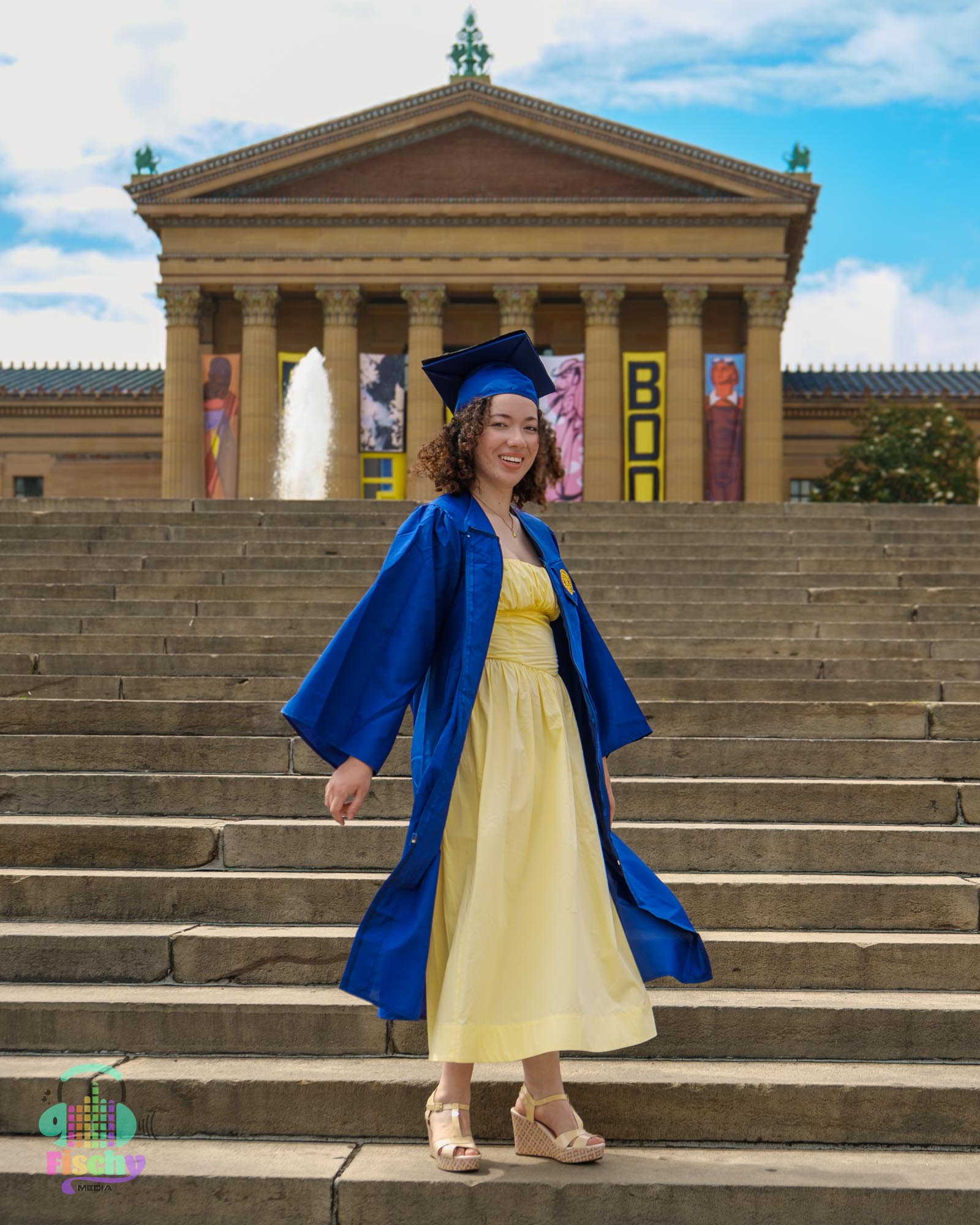 college graduate girl
graduate wearing cap and gown
graduate posing on steps
philadelphia museum
graduation photoshoot
grad pics