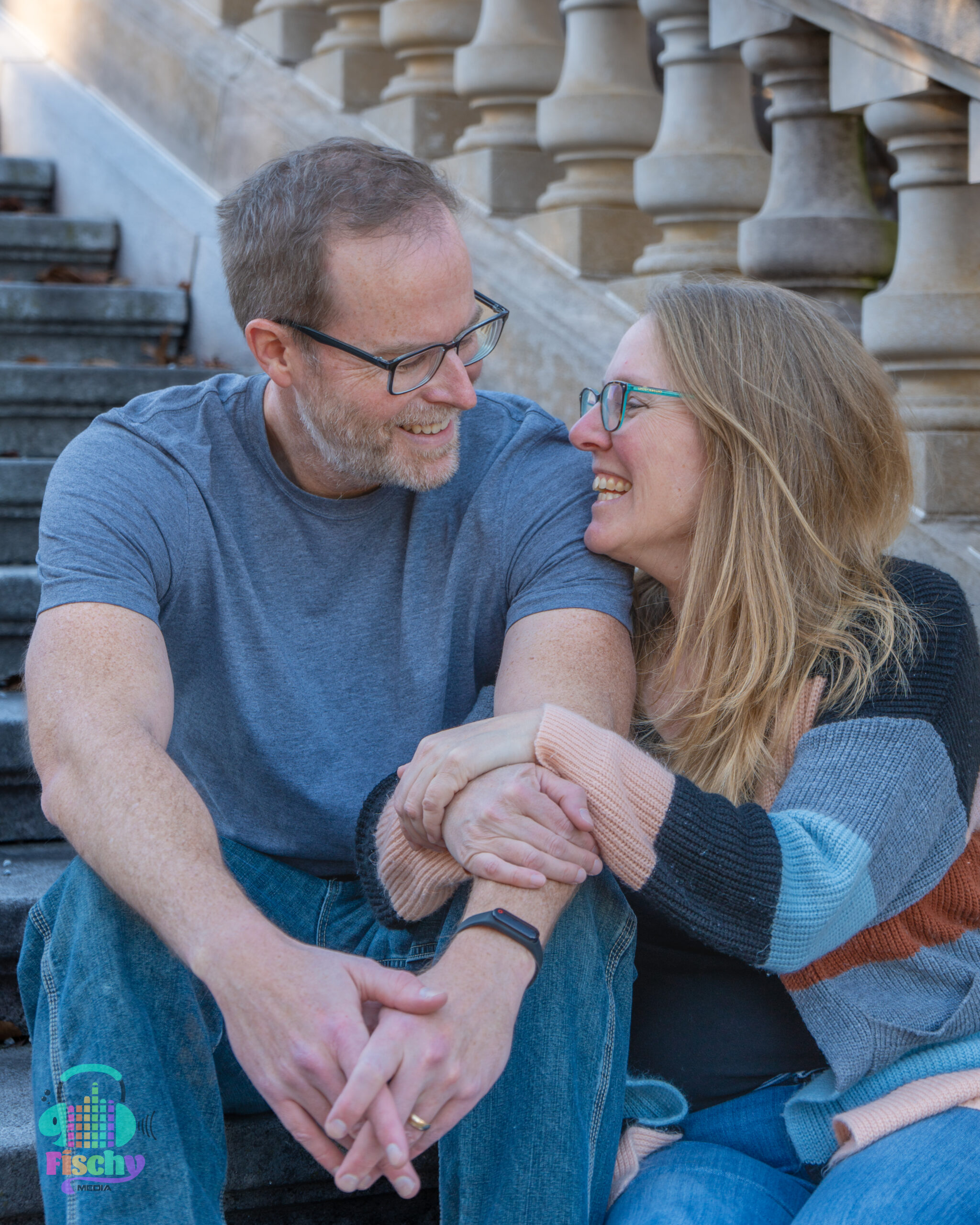 middle aged couple
sitting on steps smiling